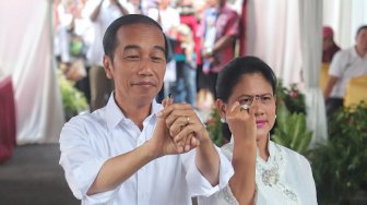 Calon Presiden nomor urut 01 Joko Widodo menggunakan hak suaranya di TPS, Jakarta Pusat, Rabu (17/4). [Suara.com/Muhaimin A Untung]