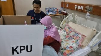 Seorang pasien menggunakan hak pilihnya di TPS 034, RSCM, Rabu (17/4). [Suara.com/Muhaimin A Untung]
