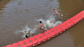 Sejumlah anak bermain di Sungai Ciliwung, Jakarta, Kamis (18/4). [Suara.com/Muhaimin A Untung]