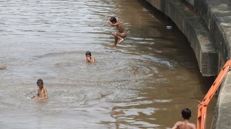 Sejumlah anak bermain di Sungai Ciliwung, Jakarta, Kamis (18/4). [Suara.com/Muhaimin A Untung]