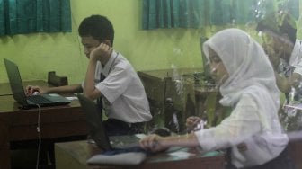 Pelajar mengikuti Ujian Nasional Berbasis Komputer (UNBK) di SMPN 85 Jakarta, Jakarta Selatan, Senin (22/4). [Suara.com/Arief Hermawan P]