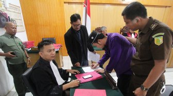 Terdakwa kasus tindak pidana narkotika Kaharuddin alias Achong berdiri usai menjalani sidang vonis di Pengadilan Negeri Dumai di Dumai, Riau, Selasa (23/4). [ANTARA FOTO/Aswaddy Hamid]