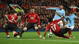 Gelandang Manchester City Raheem Sterling menembak tetapi gagal mencetak gol selama pertandingan sepak bola Liga Premier Inggris antara Manchester United melawan Manchester City di Old Trafford, Manchester, Inggris, Kamis (25/4) dini hari WIB. [Oli SCARFF / AFP]