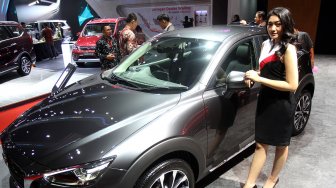 Sales Promotion Girl (SPG) berpose saat gelaran Indonesia International Motor Show (IIMS) 2019 di JIEXpo Kemayoran, Jakarta, Kamis (25/4). [Suara.com/Arief Hermawan P]