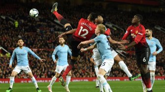 Bek Manchester United Chris Smalling bersaing dengan gelandang Manchester City Fernandinho dan gelandang Manchester City Oleksandr Zinchenko selama pertandingan sepak bola Liga Premier Inggris antara Manchester United melawan Manchester City di Old Trafford, Manchester, Inggris, Kamis (25/4) dini hari WIB. [Oli SCARFF / AFP]