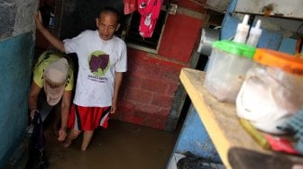 Warga memeriksa barang-barang didalam rumah yang tergenang banjir di kawasan Kampung Jawa, Pejaten Timur, Jakarta Selatan, Jumat (26/4). [Suara.com/Arief Hermawan P]