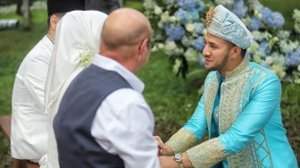 Pasangan Ammar Zoni sungkeman bersama orang tua saat acara akad nikah di Bandung, Jawa Barat, Minggu (28/4). [Suara.com/Muhaimin A Untung]