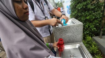 Warga mencoba fasilitas air siap minum di Stasiun MRT Dukuh Atas, Jakarta, Selasa (30/4). [Suara.com/Muhaimin A Untung]