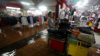 Seorang karyawan menata pakaian di Hi-Tech Mall yang terendam banjir di Surabaya, Jawa Timur, Senin (29/4). [ANTARA FOTO/Moch Asim]