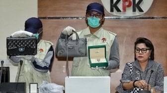 Wakil Ketua KPK Basaria Panjaitan bersama penyidik menunjukkan barang bukti berupa tas dan jam tangan mewah yang diamankan dalam Operasi Tangkap Tangan (OTT) Bupati Kepulauan Talaud Provinsi Sulawesi Utara Sri Wahyumi Maria Manalip di gedung KPK, Jakarta, Selasa (30/4). [Suara.com/Muhaimin A Untung]