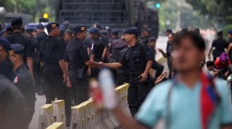 Aparat Kepolisian dilengkapi kendaraan taktis berjaga di kawasan Monas, Jakarta, Rabu (1/5). [Suara.com/Arief Hermawan p]