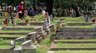 Warga berziarah kubur di Tempat Pemakaman Umum Karet Tengsin, Jakarta, Rabu (1/5). [Suara.com/Arief Hermawan P]
