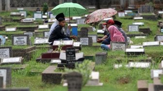 Warga berziarah kubur di Tempat Pemakaman Umum Karet Tengsin, Jakarta, Rabu (1/5). [Suara.com/Arief Hermawan P]
