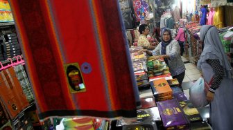 Calon pembeli memilih perlengkapan ibadah di pasar Tanah Abang, Jakarta, Kamis (2/5). [Suara.com/Arief Hermawan P]
