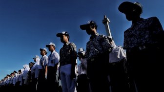 Sejumlah siswa mengikuti upacara bendera peringatan Hari Pendidikan Nasional di Lapangan Silang Monas, Jakarta, Kamis (2/5). [Suara.com/Muhaimin A Untung]