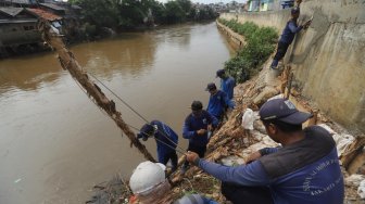 Sejumlah pasukan Sumber Daya Air DKI Jakarta memperbaiki tanggul sungai Ciliwung, Jakarta, Jumat (3/5).[Suara.com/Muhaimin A Untung]