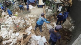 Sejumlah pasukan Sumber Daya Air DKI Jakarta memperbaiki tanggul sungai Ciliwung, Jakarta, Jumat (3/5).[Suara.com/Muhaimin A Untung]