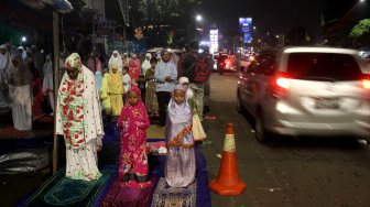Umat muslim menunaikan ibadah shalat Tarawih pertama di JPO dan halaman Musholla Miftahul Janah, Pasar Gembrong, Jakarta, Minggu (5/5). [Suara.com/Arief Hermawan P]