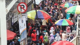 Pengunjung memadati "Skybridge" Pasar Tanah Abang, Jakarta, Minggu (5/5). [Suara.com/Muhaimin A Untung]
