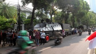 Sejumlah personel Kepolisian berjaga di sekitar kantor KPU yang dipasangi kawat berduri di Jalan Imam Bonjol, Jakarta, Kamis (9/5). [Suara.com/Arief Hermawan P]
