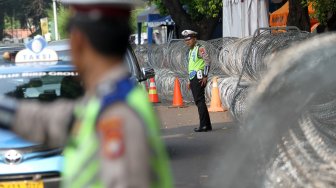 Sejumlah personel Kepolisian berjaga di sekitar kantor KPU yang dipasangi kawat berduri di Jalan Imam Bonjol, Jakarta, Kamis (9/5). [Suara.com/Arief Hermawan P]
