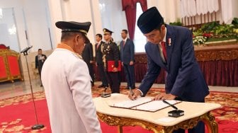 Presiden Joko Widodo (kanan) membubuhkan tanda tangan disaksikan Gubernur Maluku Utara Abdul Gani Kasuba (kiri) saat pelantikan di Istana Negara Jakarta, Jumat (10/5). ANTARA FOTO/Wahyu Putro A