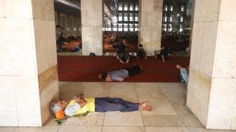 Jamaah saat melaksanakan tidur siang di ruang utama masjid Istiqlal, Jakarta Pusat, Sabtu (11/5). [Suara.com/Muhaimin A Untung]