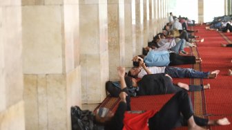 Jamaah saat melaksanakan tidur siang di ruang utama masjid Istiqlal, Jakarta Pusat, Sabtu (11/5). [Suara.com/Muhaimin A Untung]