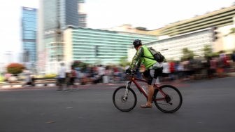 Warga beraktifitas saat Hari Bebas Kendaraan Bermotor atau Car Free Day (CFD) di kawasan Bundaran HI, Jakarta, Minggu (12/5). [Suara.com/Arief Hermawan P]
