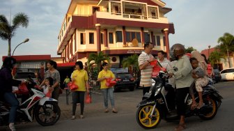 Sejumlah umat Buddha membagikan makanan untuk berbuka puasa (takjil) kepada pengendara di depan gedung Pusat Pelatihan Meditasi Arama Maha Buddha, Maassar, Sulawesi Selatan, Minggu (12/5). [ANTARA FOTO/Abriawan Abhe]