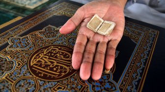 Al Quran berukuran mini yang ditulis dengan tinta emas di Masjid Jami Daarussalaam, Pasir Jambu, Kabupaten Bogor, Jawa Barat, Senin (13/5). [Suara.com/Arief Hermawan P]