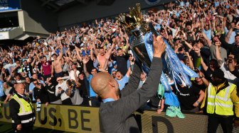 Manajer Manchester City Pep Guardiola merayakan gelar juara Liga Inggris 2018/2019 di American Express Community Stadium, Brighton, Inggris, Minggu (12/5). [Glyn KIRK / AFP]