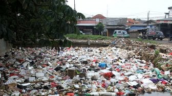 Kendaraan melintas di sekitar kali Baru yang dipenuhi sampah di Jalan Pabuaran, Bojonggede, Kabupaten Bogor, Jawa Barat, Selasa (14/5). [Suara.com/Arief Hermawan P]