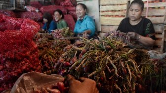 Pedagang merapihkan bawang merah di Pasar Induk Kramat Jati, Rabu (15/5). [Suara.com/Muhaimin A Untung]