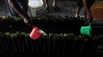 Pekerja menyelesaikan pembuatan Lemang di kawasan Pasar Senen, Jakarta, Jumat (17/5). [Suara.com/Arief Hermawan P]