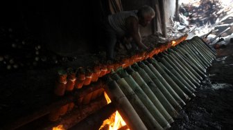 Pekerja menyelesaikan pembuatan Lemang di kawasan Pasar Senen, Jakarta, Jumat (17/5). [Suara.com/Arief Hermawan P]