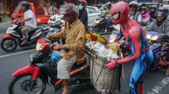 Warga mengenakan kostum superhero Spiderman membagikan takjil kepada pengguna jalan saat kegiatan Bagi-Bagi Takjil Komunitas Cosplay di jalan Gatot Subroto, Solo, Jawa Tengah, Minggu (19/5). [ANTARA FOTO/Mohammad Ayudha]