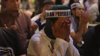 Massa Gerakan Nasional Kedaulatan Rakyat menunaikan shalat Tarawih di sela aksi unjuk rasa di depan Kantor Bawaslu Jakarta, Selasa (21/5). [Suara.com/Muhaimin A Untung]