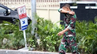 Warga menutupi mata dan hidungnya saat melintas di sekitar gedung Bawaslu, Jalan MH Thamrin, Jakarta, Kamis (23/5). [Suara.com/Arief Hermawan P]