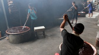 Pekerja membuat dodol Betawi di Kalibata, Jakarta, Jumat (24/5). [suara.com/Oke Atmaja]