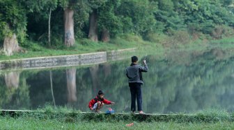 Wisatawan menikmati pemandangan Situ Gunung yang berada di Cisaat, Kabupaten Sukabumi, Jawa Barat, Sabtu (25/5). [Suara.com/Arief Hermawan P]
