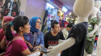 Pengunjung saat berbelanja pakaian di Blok A Pasar Tanah Abang, Jakarta, Minggu (26/5). [Suara.com/Muhaimin A Untung]