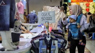 Pengunjung saat berbelanja pakaian di Blok A Pasar Tanah Abang, Jakarta, Minggu (26/5). [Suara.com/Muhaimin A Untung]