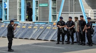 Warga berfoto dengan petugas polisi di Gedung Badan Pengawas Pemilu (Bawaslu) saat Hari Bebas Kendaraan Bermotor di kawasan Sarinah, Jakarta, Minggu (26/5). [Suara.com/Muhaimin A Untung]