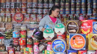 Sejumlah calon pembeli memilih kue kering dalam kemasan di lapak penjual kue musiman di depan pabrik Khong Guan, Jalan Raya Bogor Km. 26, Ciracas, Jakarta Timur, Senin (27/5). [Suara.com/Muhaimin A Untung]