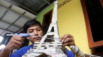 Pengrajin menyelesaikan pembuatan kerajinan tangan berbahan baku limbah kertas koran di Dapur Akasia Art, Jalan Akasia, Pamulang, Tangerang Selatan, Banten, Rabu (29/5). [Suara.com/Arief Hermawan P]