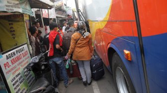 Sejumlah penumpang menunggu Bus Antar Kota Antar Provinsi (AKAP) di terminal bus bayangan di Jalan Raya Bogor, Pal, Depok, Jawa Barat, Jumat (31/5).[Suara.com/Arief Hermawan P]