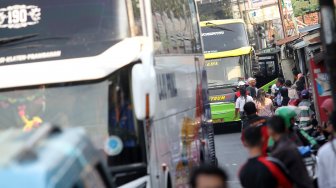 Sejumlah penumpang menunggu Bus Antar Kota Antar Provinsi (AKAP) di terminal bus bayangan di Jalan Raya Bogor, Pal, Depok, Jawa Barat, Jumat (31/5).[Suara.com/Arief Hermawan P]