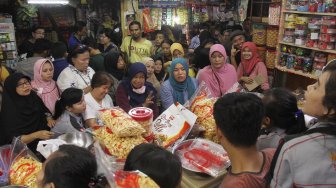 Warga mengantre membeli kue kering di pasar Jatinegara, Jakarta, Sabtu (1/6).[Suara.com/Oke Atmaja]