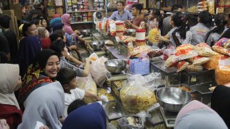 Warga mengantre membeli kue kering di pasar Jatinegara, Jakarta, Sabtu (1/6).[Suara.com/Oke Atmaja]